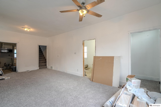 interior space with ceiling fan and carpet floors