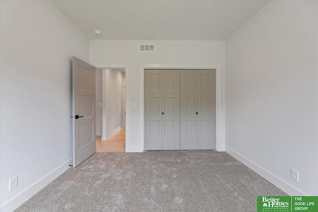 unfurnished bedroom with light carpet and a closet