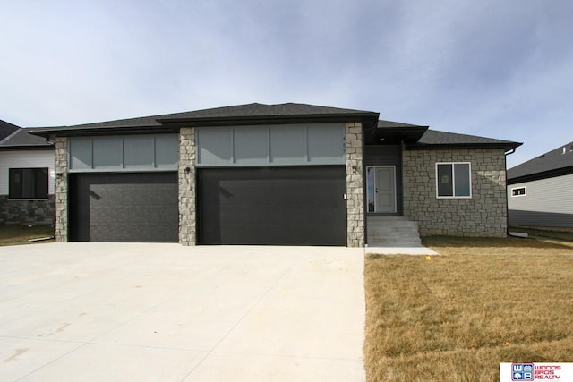 prairie-style home with a garage and a front yard