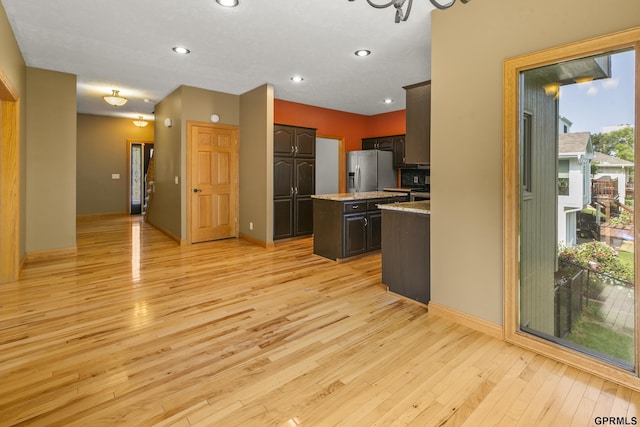 kitchen featuring a center island, stainless steel fridge with ice dispenser, light hardwood / wood-style floors, dark brown cabinetry, and a chandelier