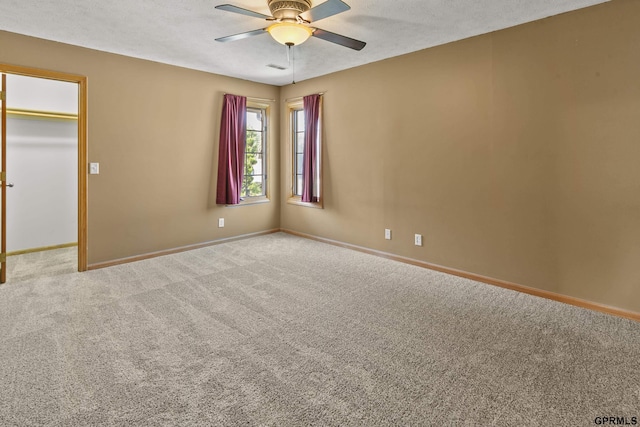 unfurnished room with a textured ceiling, light colored carpet, and ceiling fan