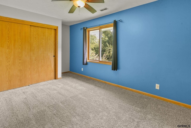 unfurnished bedroom with carpet, a closet, and ceiling fan