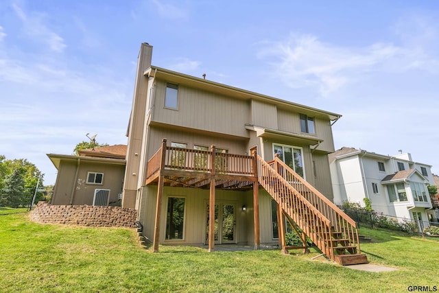 back of property with a deck and a yard