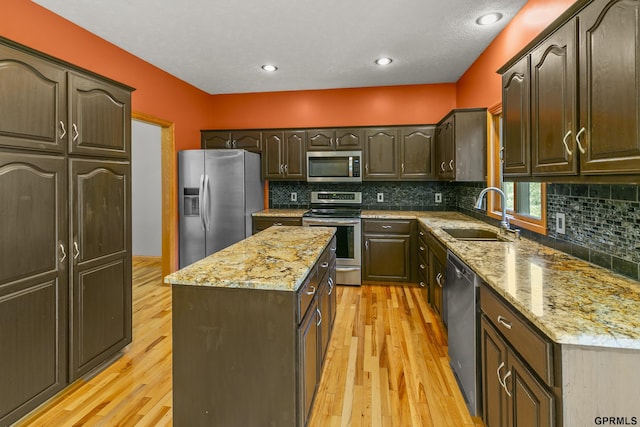 kitchen with sink, stainless steel appliances, dark brown cabinets, and light hardwood / wood-style floors