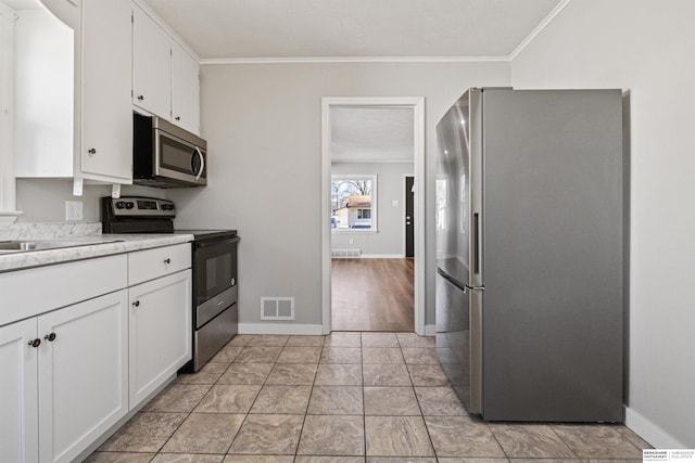 kitchen with ornamental molding, stainless steel appliances, white cabinetry, and sink