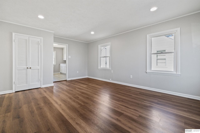 unfurnished bedroom featuring ensuite bathroom, ornamental molding, and dark hardwood / wood-style flooring