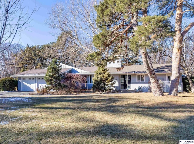 single story home featuring a garage and a front lawn