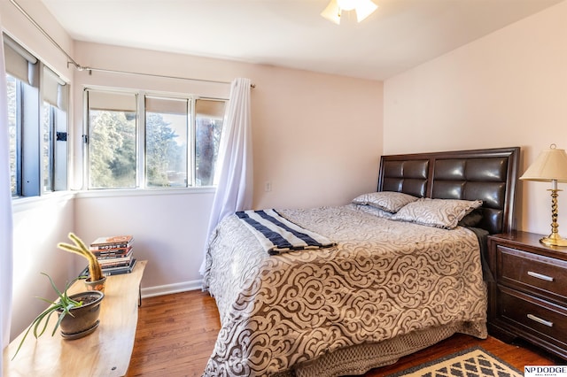 bedroom with ceiling fan and dark hardwood / wood-style floors