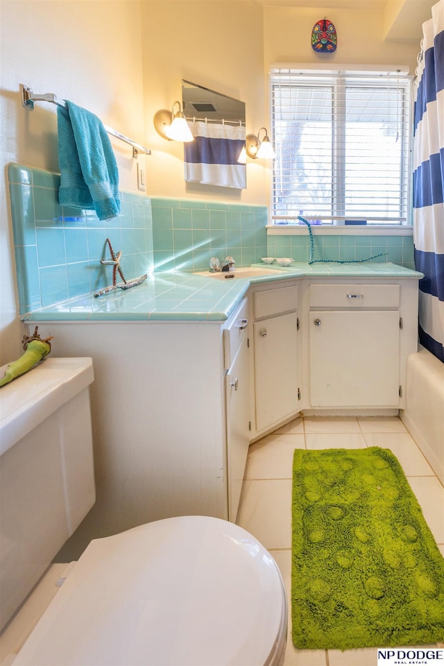 full bathroom featuring tile patterned floors, vanity, shower / bath combination with curtain, and toilet