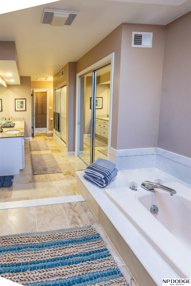 bathroom featuring plus walk in shower, vanity, and tile patterned floors