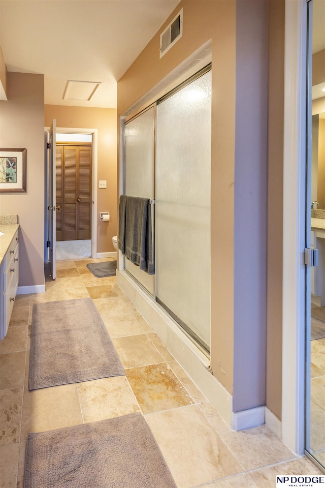 bathroom featuring vanity, toilet, and a shower with door