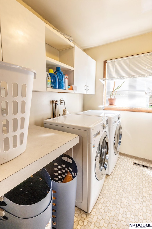 washroom featuring washer and dryer and cabinets