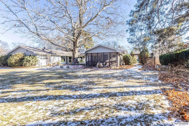 snowy yard featuring a sunroom