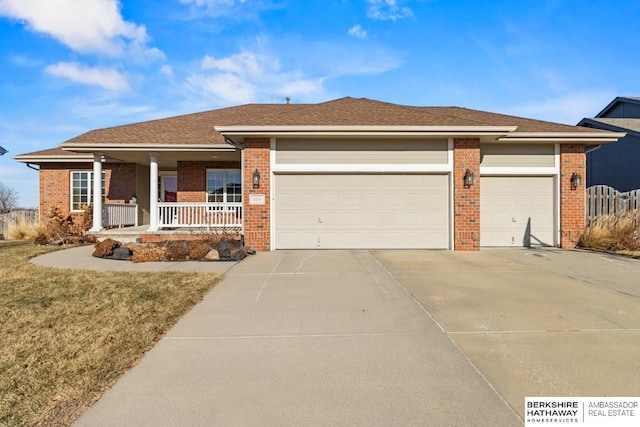 ranch-style house featuring a front yard, covered porch, and a garage