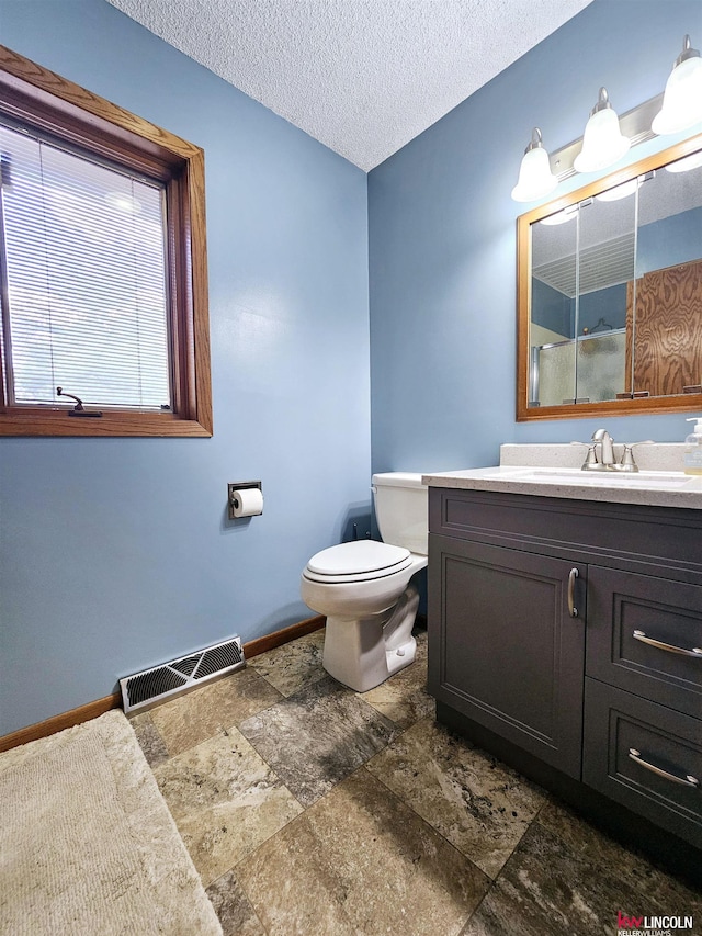 bathroom featuring vanity, a textured ceiling, and toilet