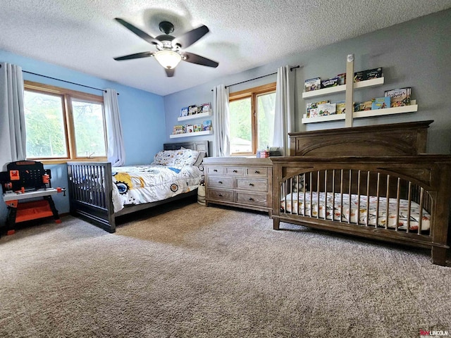 bedroom featuring a textured ceiling, carpet floors, and ceiling fan