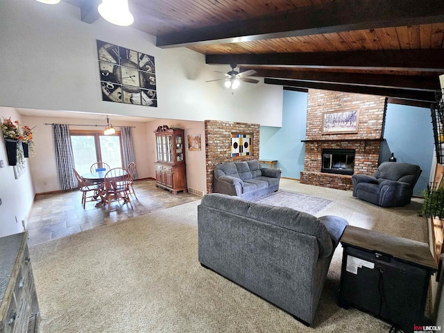 living room featuring ceiling fan, wooden ceiling, a brick fireplace, beamed ceiling, and high vaulted ceiling