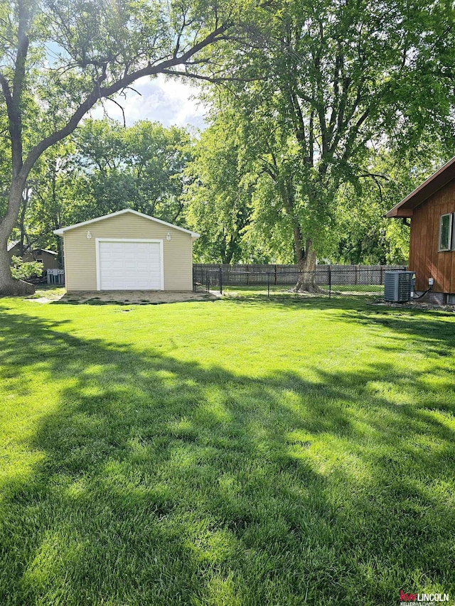 view of yard with an outbuilding, a garage, and central air condition unit