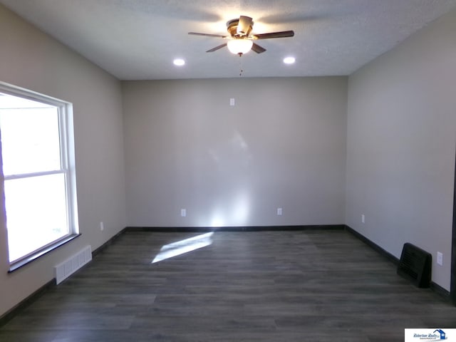 empty room featuring ceiling fan, dark hardwood / wood-style flooring, and a textured ceiling