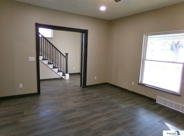 spare room with ceiling fan, dark wood-type flooring, and a healthy amount of sunlight