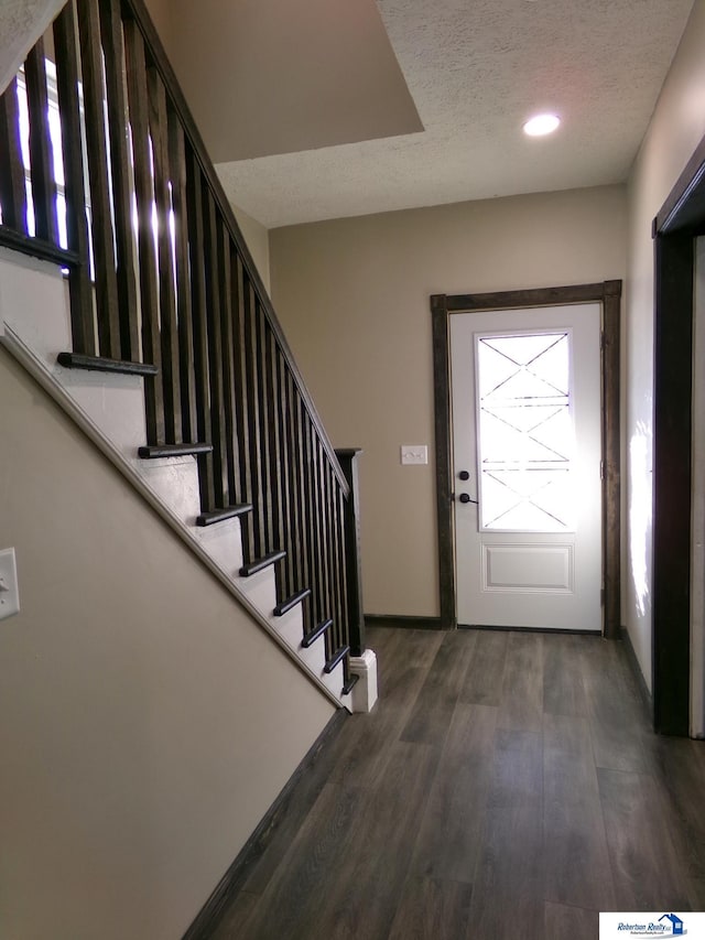 entryway featuring a textured ceiling and dark wood-type flooring