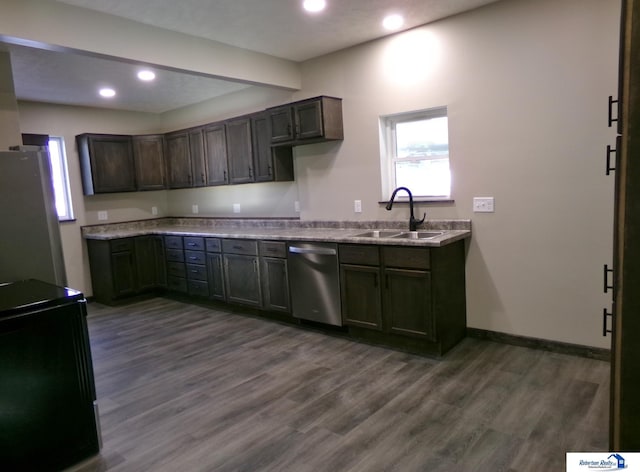 kitchen featuring dark brown cabinets, stainless steel appliances, dark hardwood / wood-style floors, and sink