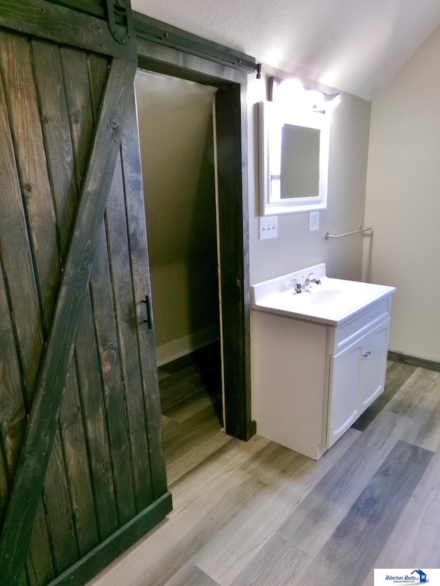 bathroom with hardwood / wood-style floors, vanity, and a textured ceiling