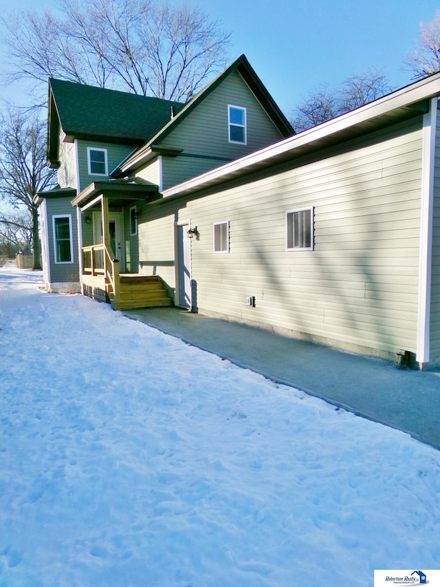 view of snow covered rear of property