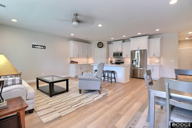 living room featuring light hardwood / wood-style floors and ceiling fan