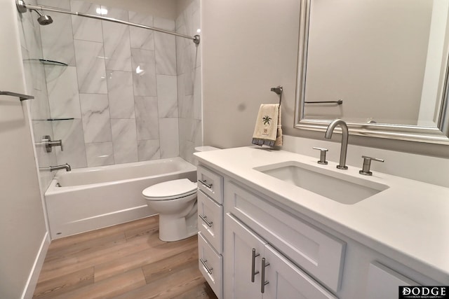 full bathroom with hardwood / wood-style floors, vanity, toilet, and tiled shower / bath