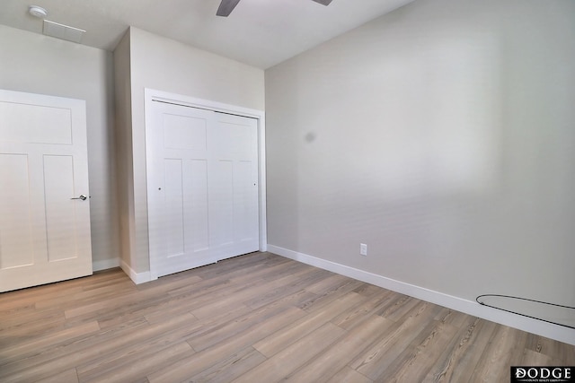 unfurnished bedroom featuring a closet, light hardwood / wood-style flooring, and ceiling fan