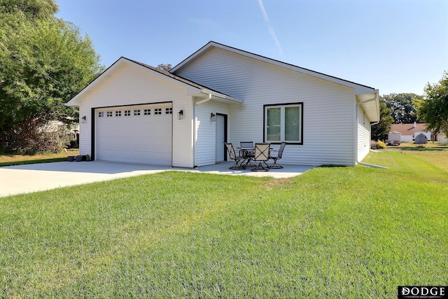 view of front of house featuring a front lawn, a patio, and a garage