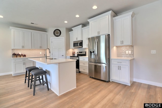 kitchen with white cabinetry, a kitchen island with sink, and appliances with stainless steel finishes