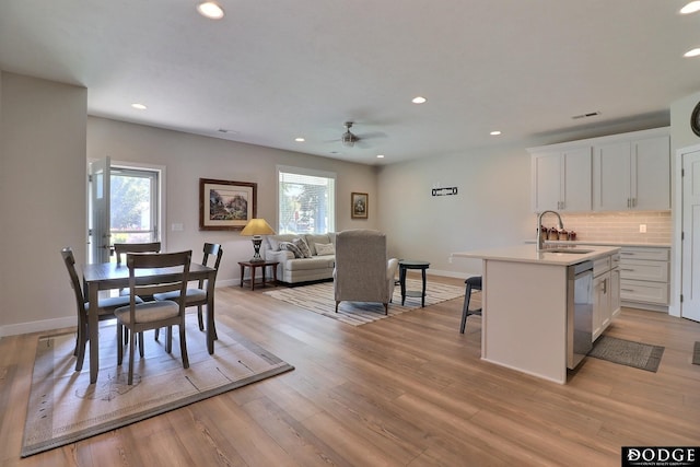 dining space featuring ceiling fan, sink, and light hardwood / wood-style floors