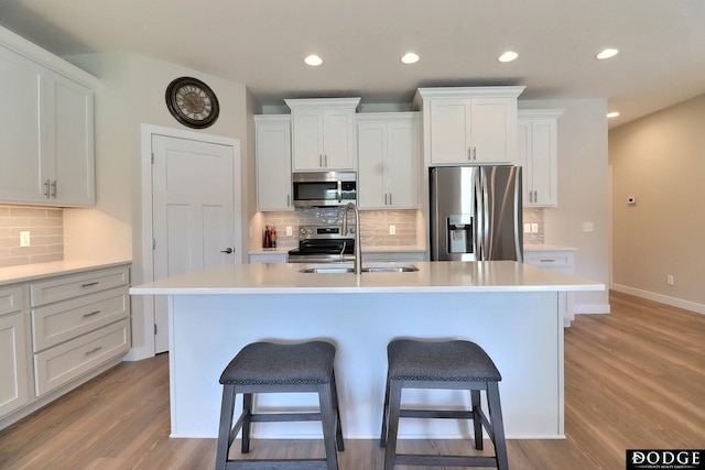 kitchen with appliances with stainless steel finishes, a kitchen island with sink, and sink