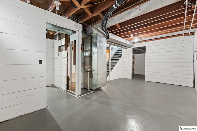 basement with heating unit and wooden walls