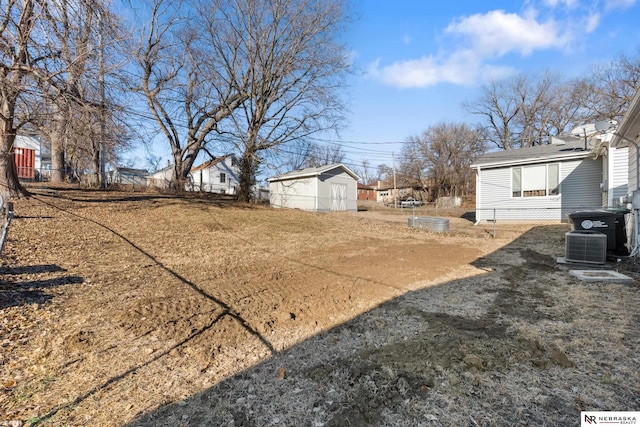 view of yard with central AC unit and a storage unit