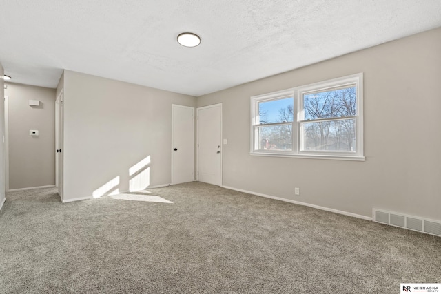 unfurnished room featuring carpet floors and a textured ceiling