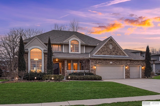 view of front of property featuring a porch, a yard, and a garage