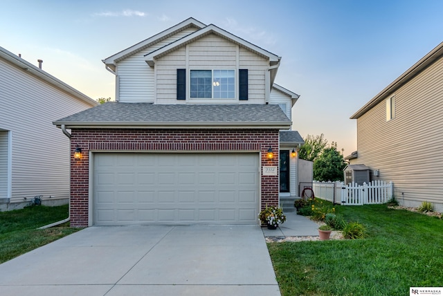 front of property featuring a lawn and a garage