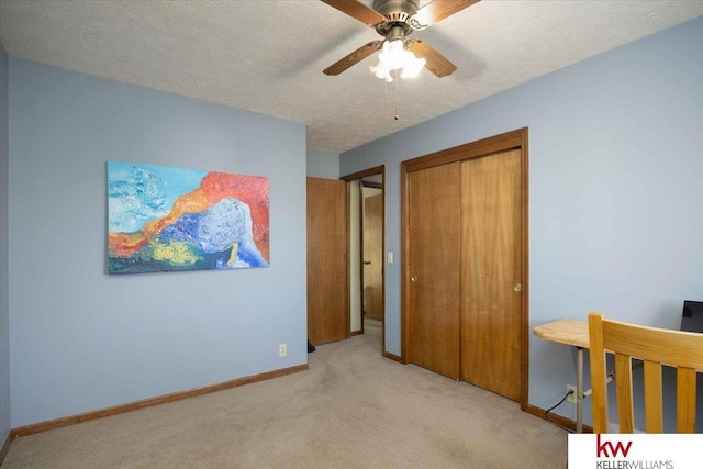 bedroom with ceiling fan, light colored carpet, a closet, and a textured ceiling