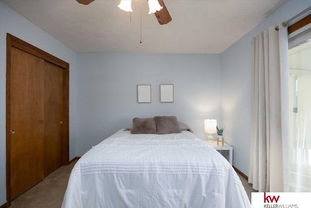 bedroom featuring ceiling fan, a closet, and light carpet