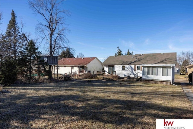 back of house with a yard and a sunroom