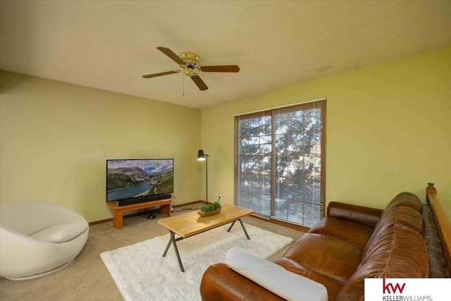 living room featuring ceiling fan, light colored carpet, and a textured ceiling