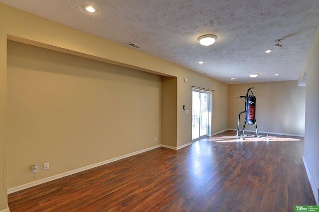 exercise room with a textured ceiling and dark hardwood / wood-style floors