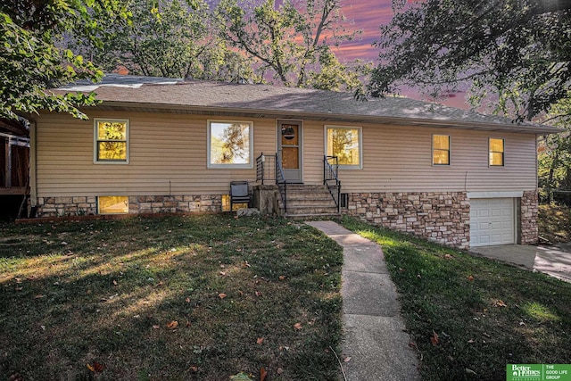 view of front of home with a yard and a garage