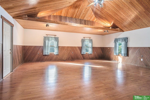 empty room with vaulted ceiling, wood ceiling, and hardwood / wood-style floors