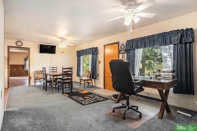 carpeted home office featuring ceiling fan