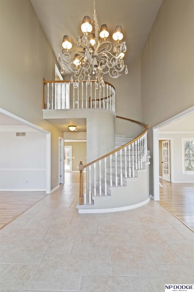 stairway featuring hardwood / wood-style floors, a towering ceiling, and a chandelier