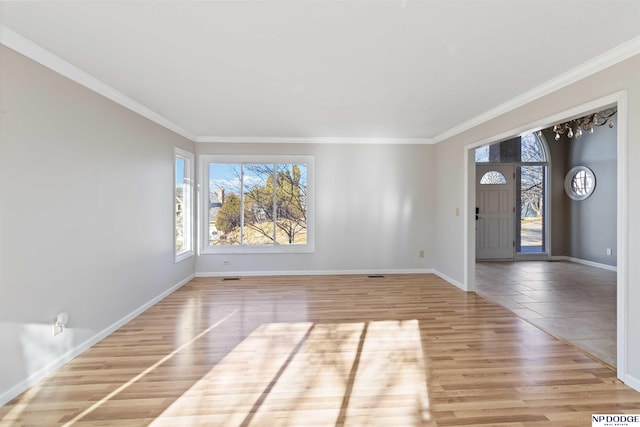 empty room featuring light hardwood / wood-style floors and crown molding